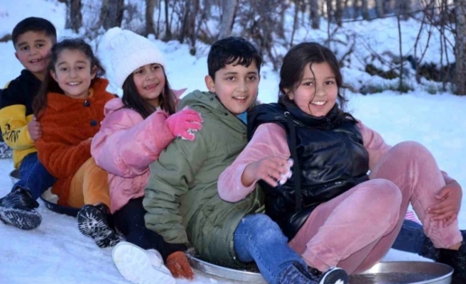 Çocuklar leğende kayarak karın keyfini yaşıyor